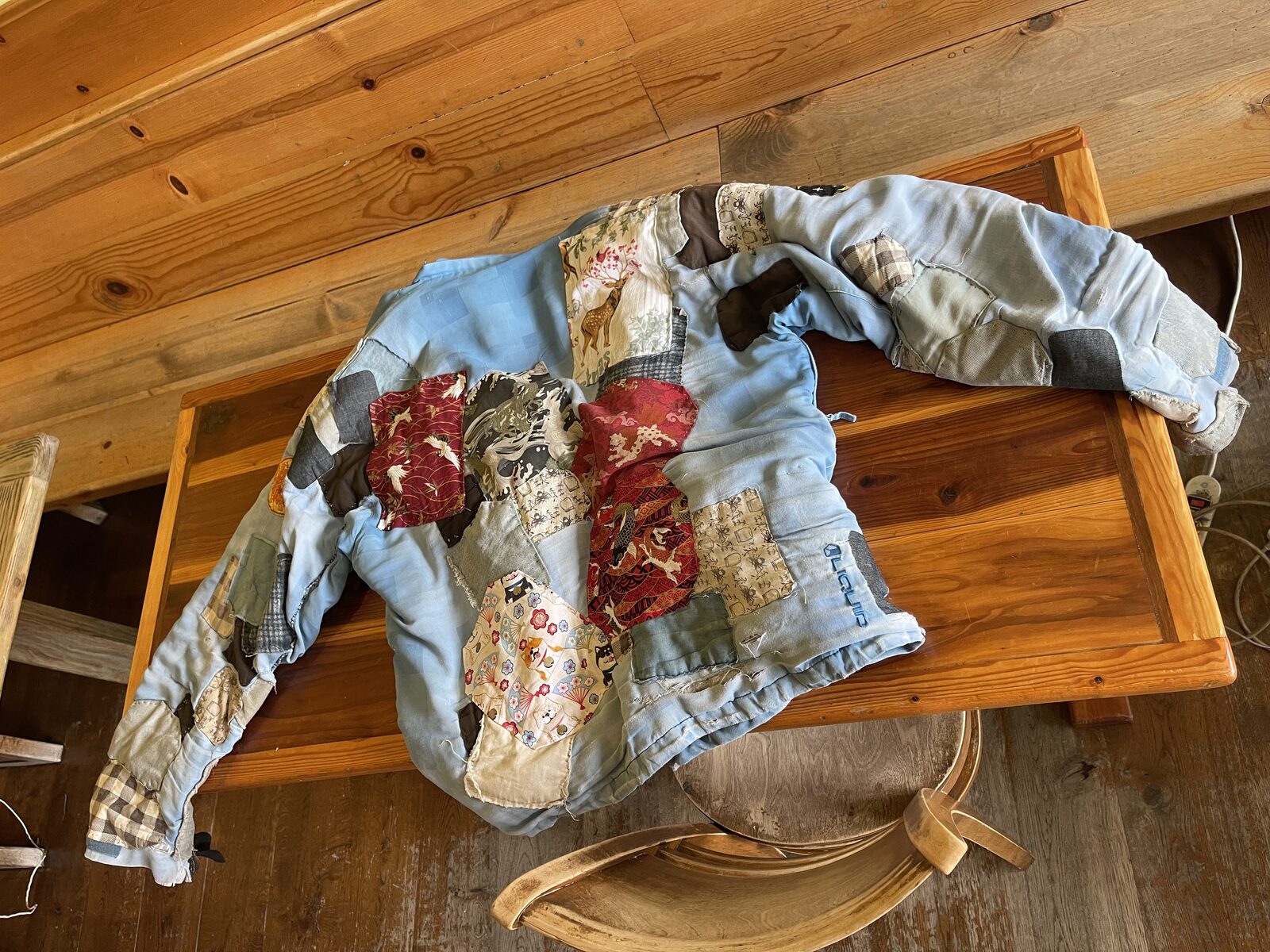 Gary's regenerative jacket — a base jacket originally bought from Amazon, now patched many times over with whatever materials happened to be handy in whichever place a rip occurred.